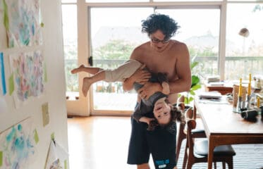 Man holding a child upside down